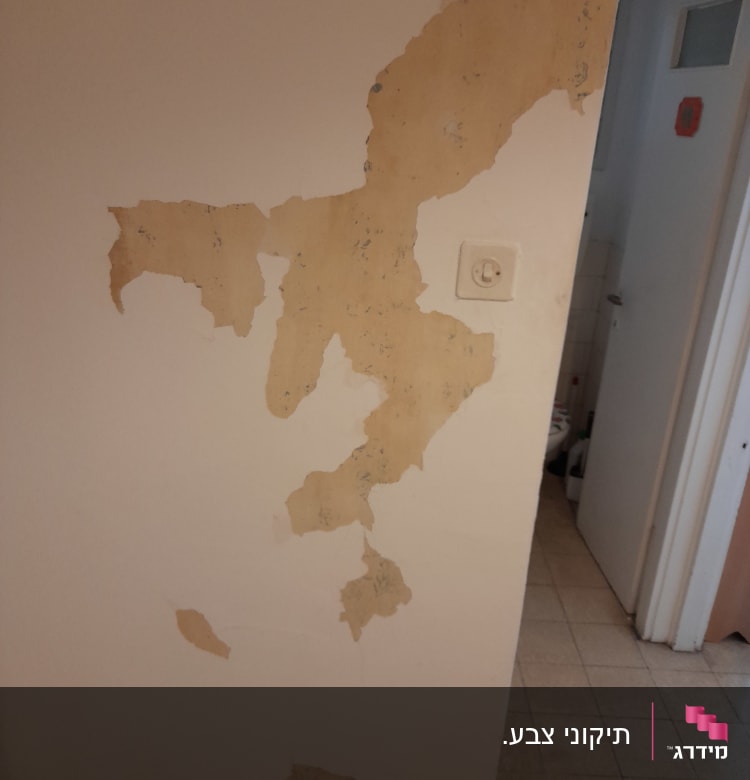 קיר עם טיח מתקלף וחשוף לצביעה